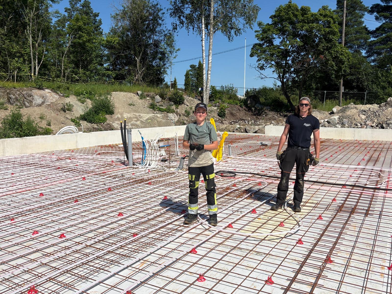 14.7.2026 Lattialämmitysputkiston asennusta Vaunutalliin -LVI Nummelin. Kuvassa vasemmalla reipas kesätyömiehemme Matias 15v.
